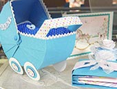 Kinderwagen aus Papier und Grußkarte als Geschenkidee zur Geburt